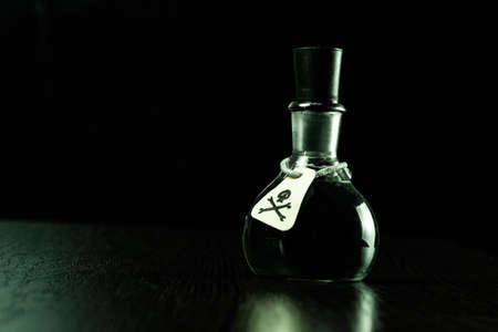 vial of poison with a hazard warning label, on a dark background, toning, short focusの写真素材