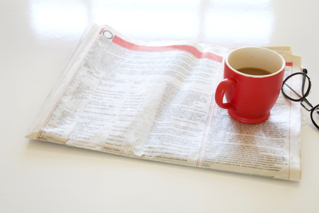 Newspaper with coffee on tableの写真素材