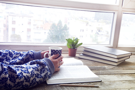 Woman hands reading book with coffeeの写真素材