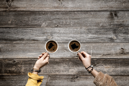 People hands drinking coffee on wooden tableの写真素材