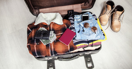 Travel concept open suitcase with casual clothesの写真素材