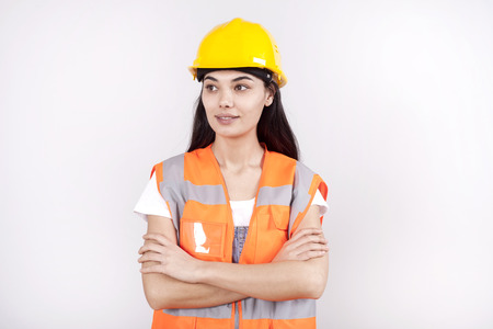 Proud serious young woman architect or engineer with arms crossed as professional building...