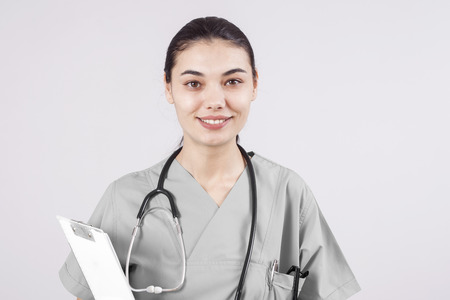 Young woman doctor portrait on gray backgroundの写真素材
