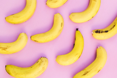 Colorful fruit pattern of fresh yellow bananas on pink backgroundの写真素材