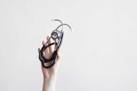 Person hand hold stethoscope on gray backgroundの写真素材