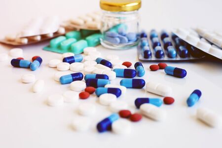 Pills and capsules on white background