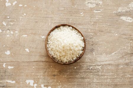 White rice in wooden bowl on wood backgroundの写真素材
