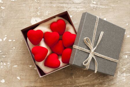 Heart in gift box on wooden background