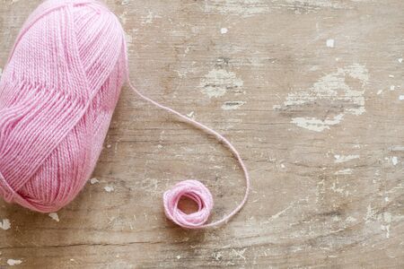 Knitting needles and wool ball isolated on wooden backgroundの写真素材