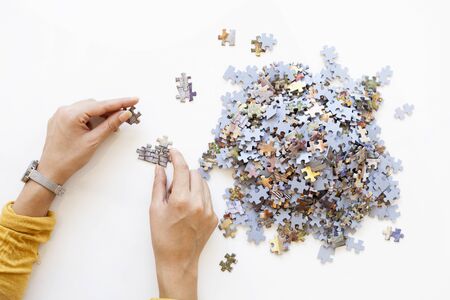 Person hands Unfinished color puzzle pieces on white background. Business concept