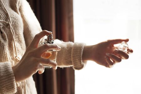 Woman sprays perfume over her delicate wirst
