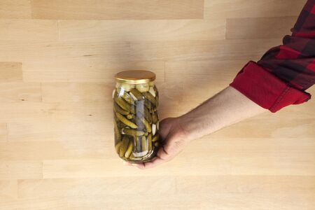 Person holding a jar of pickles Homemade pickled cucumbers in a glass jar.