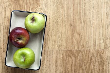 Ceramic plate in apples on wooden background.の写真素材