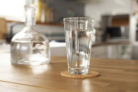 Glass of pure water and bottle on kitchen table
