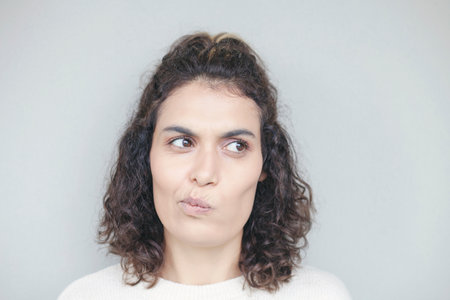 Young woman face expression on gray background.の写真素材
