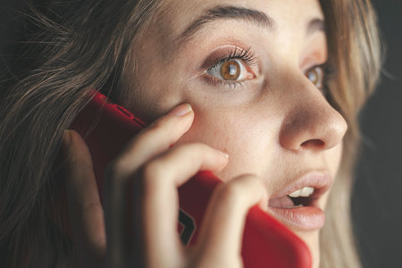 Close up portrait pretty girl of a surprised in mobile phone talkingの写真素材
