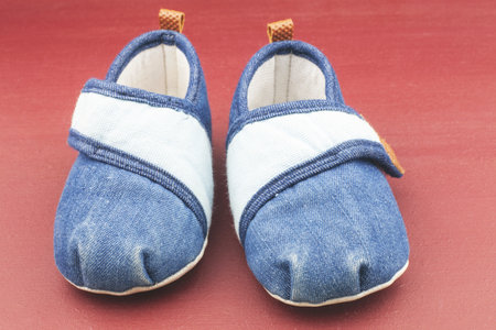 Baby shoes on red background.の写真素材