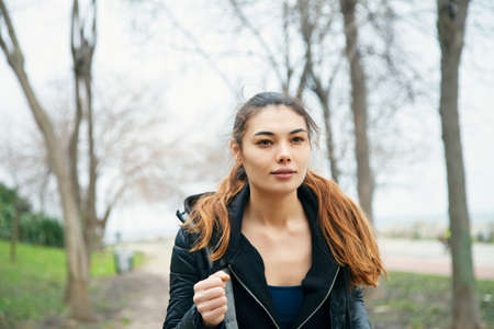 Young smiling positive attractive sportswoman with running in public park in the morning.の写真素材
