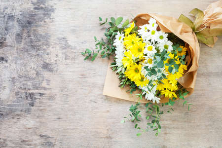 Bouquet daisy chamomile flowers on wooden garden table.の写真素材