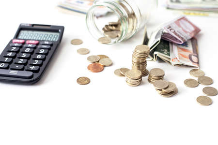 Overturned glass jar full of shined Golden coins on the white backgroundの写真素材
