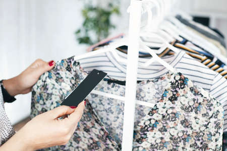 Young woman choosing clothes on a rack in a showroomの写真素材
