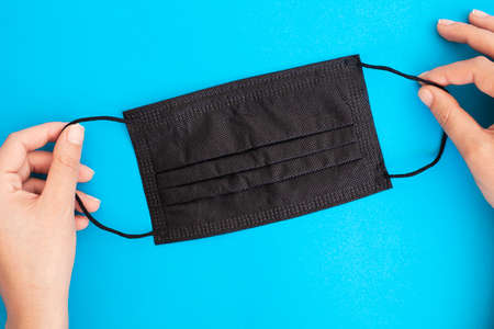 black medical mask   icon isolated on blue backgroundの写真素材