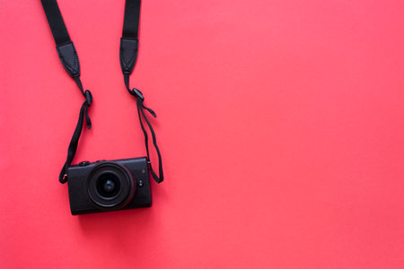 Hanging camera flat on red backgroundの写真素材