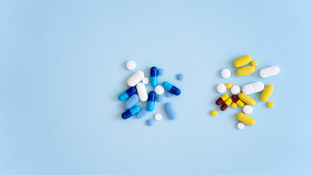 Assorted pharmaceutical medicine pills, tablets and capsules over blue backgroundの写真素材