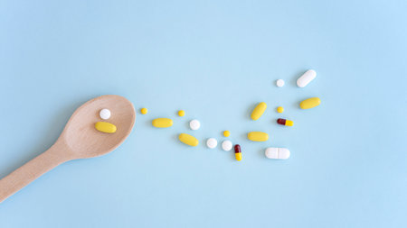 Assorted pharmaceutical medicine pills, tablets and capsules over blue backgroundの写真素材