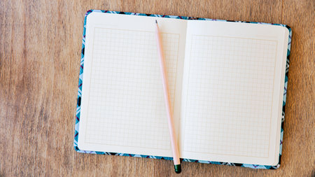 blank notebook with pen and pencil on wooden table, business conceptの写真素材