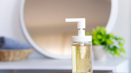 Liquid soap bottle, gray towel on basket in bathroom. Hygiene and healthy life concept. Close up, selective focusの写真素材
