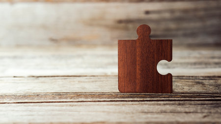 Brown pieces of puzzle stand on wooden table. Empty copy space for inscription or objects. idea, sign, symbol, concept of connectingの写真素材