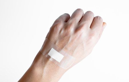 Woman hand with a band aid isolated on a white backgroundの写真素材