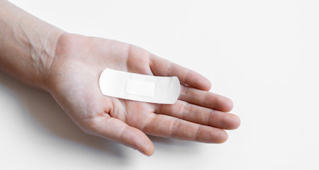 Woman hand with a band aid isolated on a white background