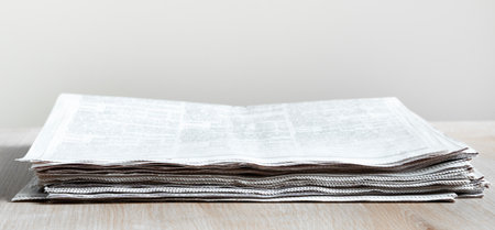 Pile of newspapers stacks on table