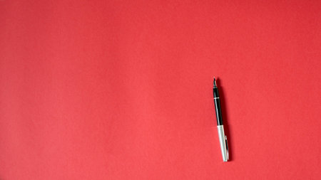 pen on isolated red background, blank spaceの写真素材