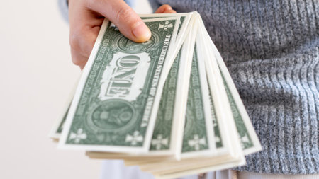 A woman hand offering dollar, euro notes and holding bunch of euro money. Euro, dollar banknotes,...