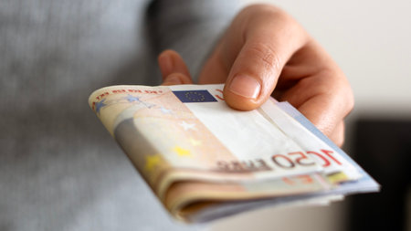 A woman hand offering dollar, euro notes and holding bunch of euro money. Euro, dollar banknotes,...