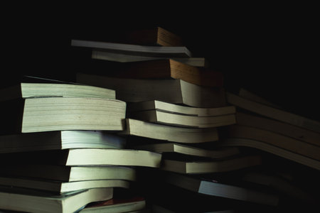 The old books heap on shelf in low light background.Dark corner in the library.Concept is  background booksの写真素材