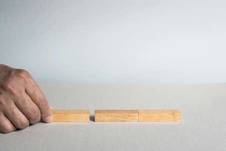 Concept Plan and strategy in business with a  wood block.The man  has place three wooden block on the table.Model for plan and strategy in Businessの写真素材