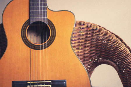 Close-up classic guitar on rattan chair.old guitarの写真素材