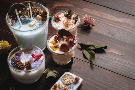Craftsmanship or Handicraft on black wooden background. Aromatic scented candle glass on black wooden table with dried potpourri and  fragrant herbs for special season.の写真素材