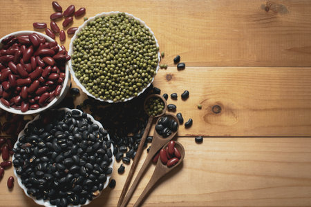 Health food components.Red beans and mung beans and black beans on the wooden background.They in the...