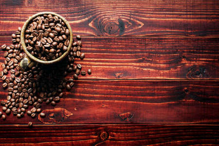 Arabica coffee beans  in green cup on the wooden background.Popular natural food products ,top left viewの写真素材