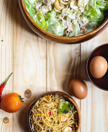 Tuna Salad and Spicy Spaghetti with ingredient  and black coffee on nature wooden backdrop ....