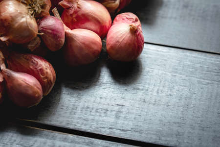 Red onions on black wooden board.Not fresh and very dry,food components,macro food photoの写真素材