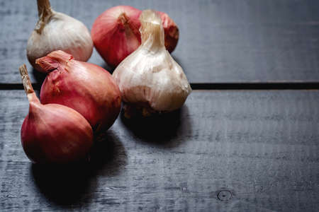 Red onions on black wooden board.Not fresh and very dry,food components,macro food photo