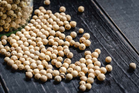 Closeup dry peppercorn seeds on black wooden board for cooking.Food ingredient  photo macroの写真素材