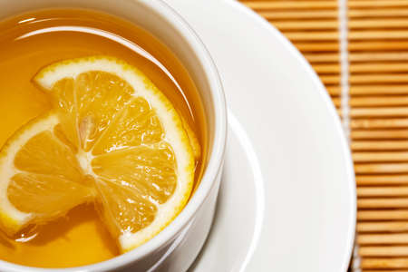 Fresh honey mixed with fresh lemon juice  and hot water in white cup for drink .Lemon slices in a cup, healty food close-upの写真素材