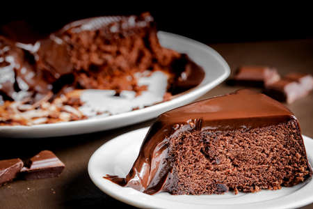 Chocolate cake slice in the white plate on the table. Close-up tasty homemade cakeの写真素材